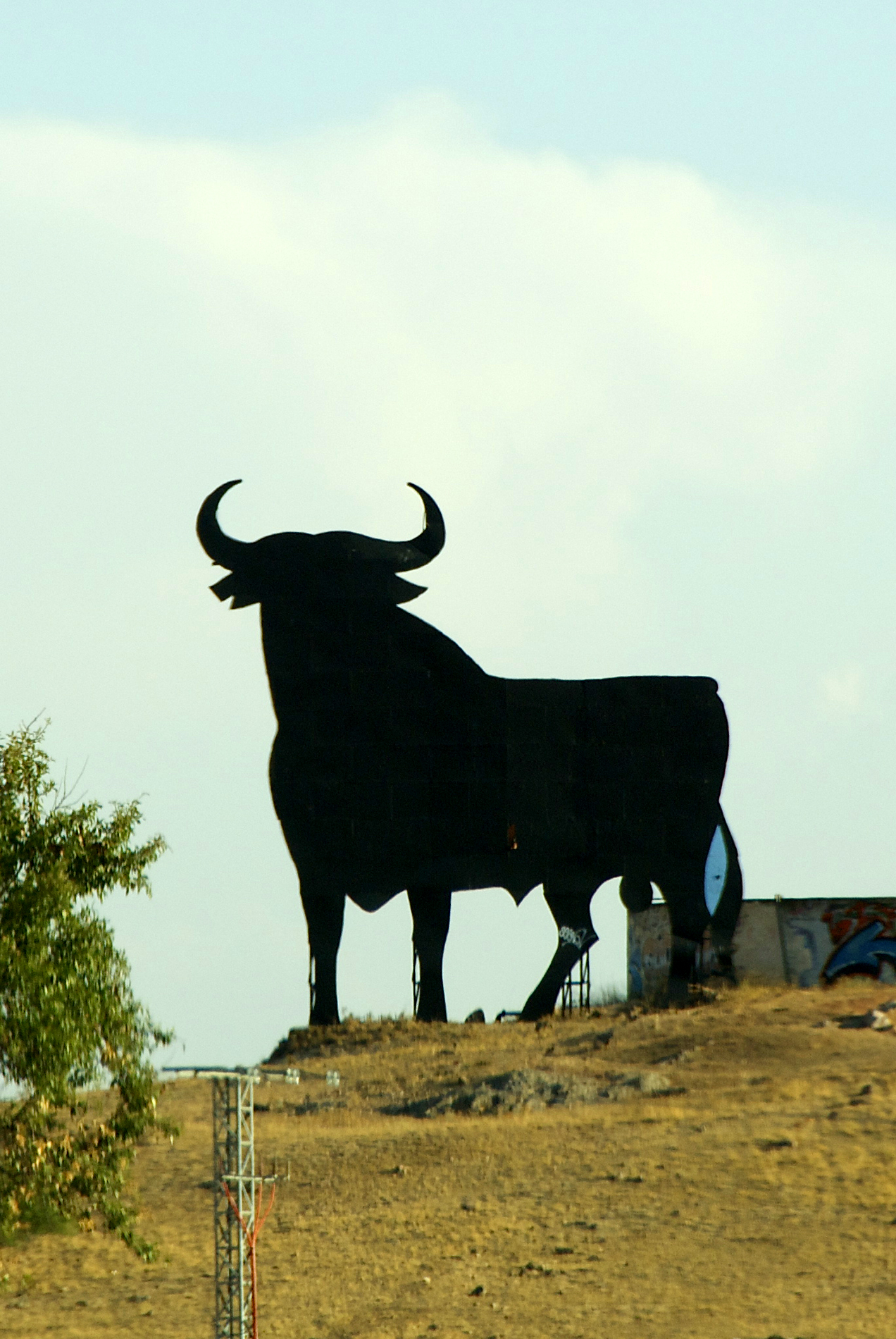 a large sculpture of a bull stands in the desert