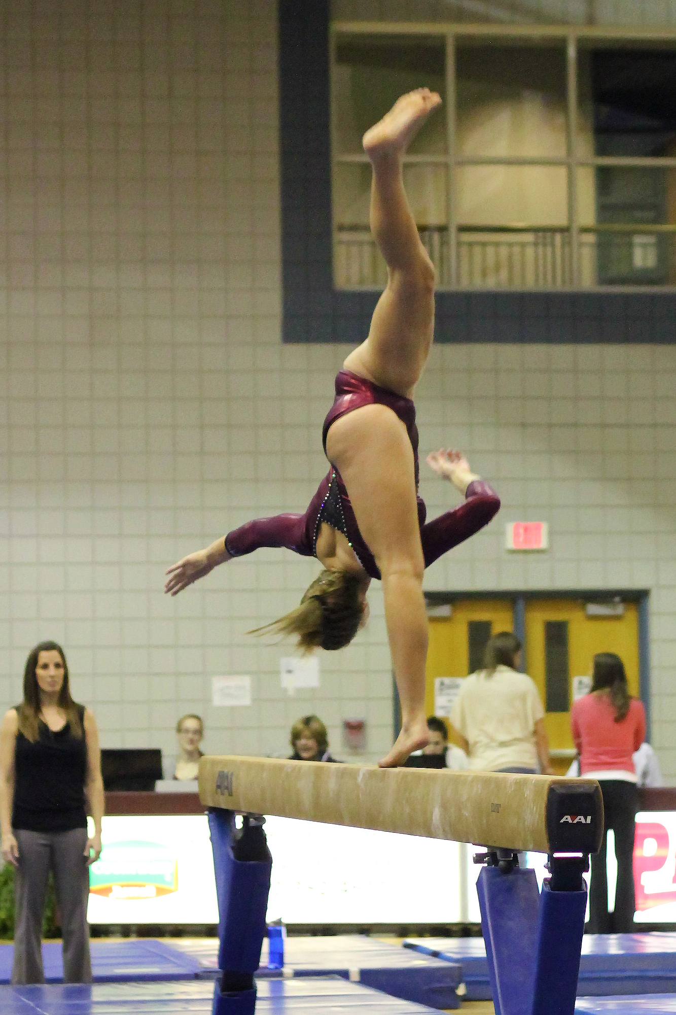 a woman on the beam doing a flip on a gymnastics track
