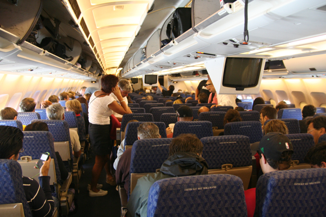 the inside of an airplane with people sitting and looking out