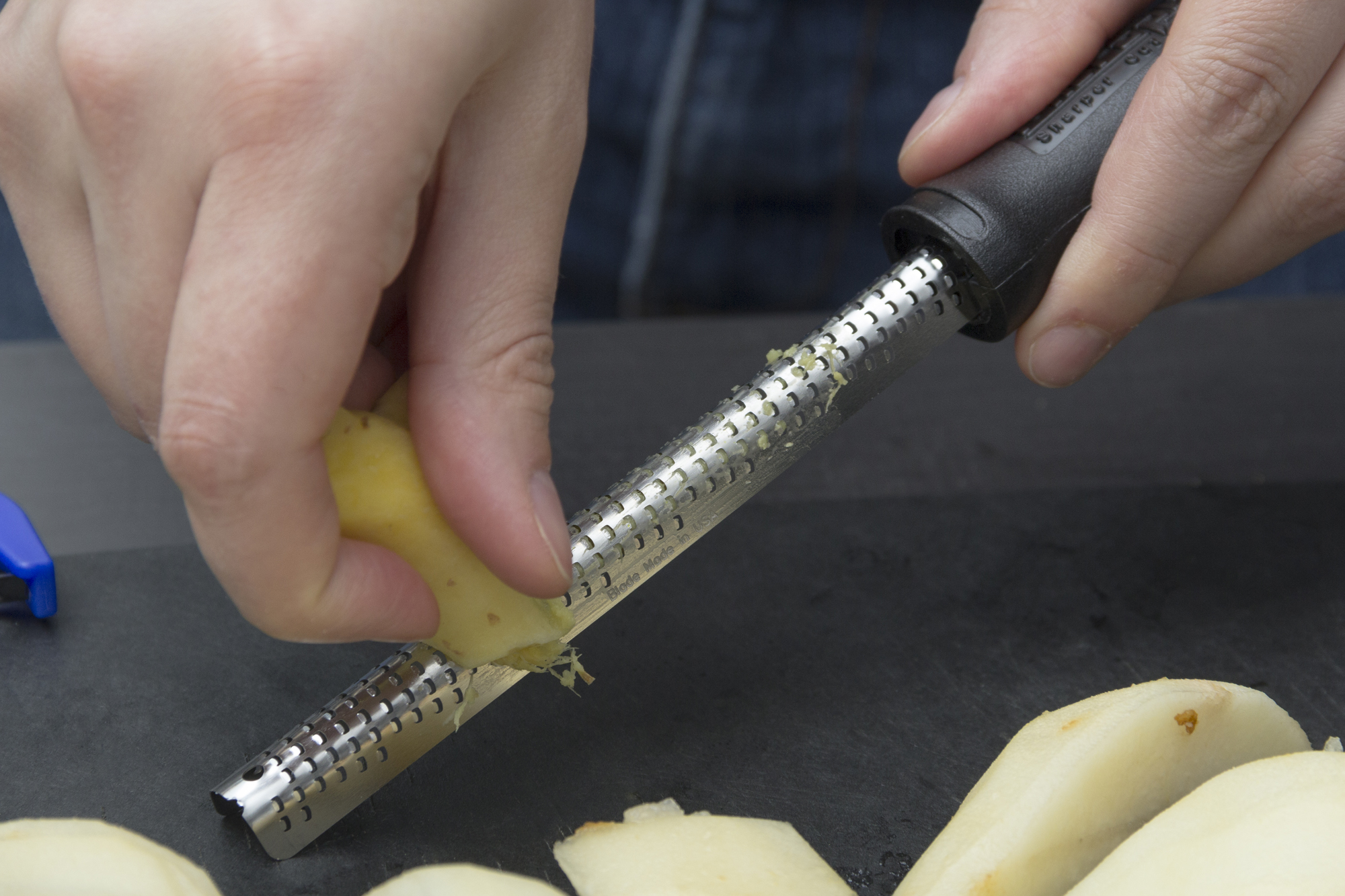 a person preparing a meal with a banana peeler