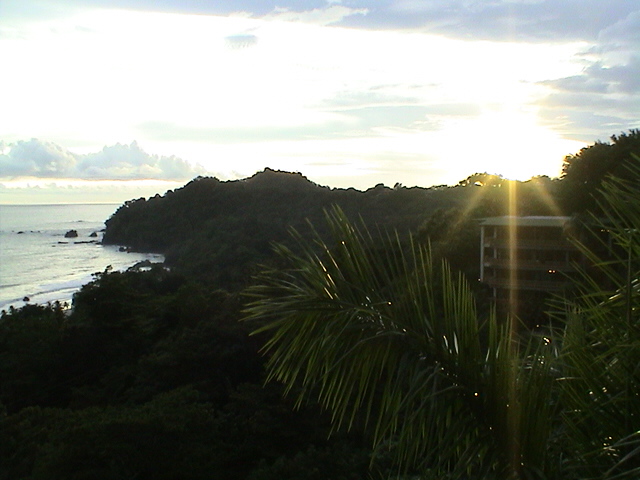 a building near the beach sitting on a hillside