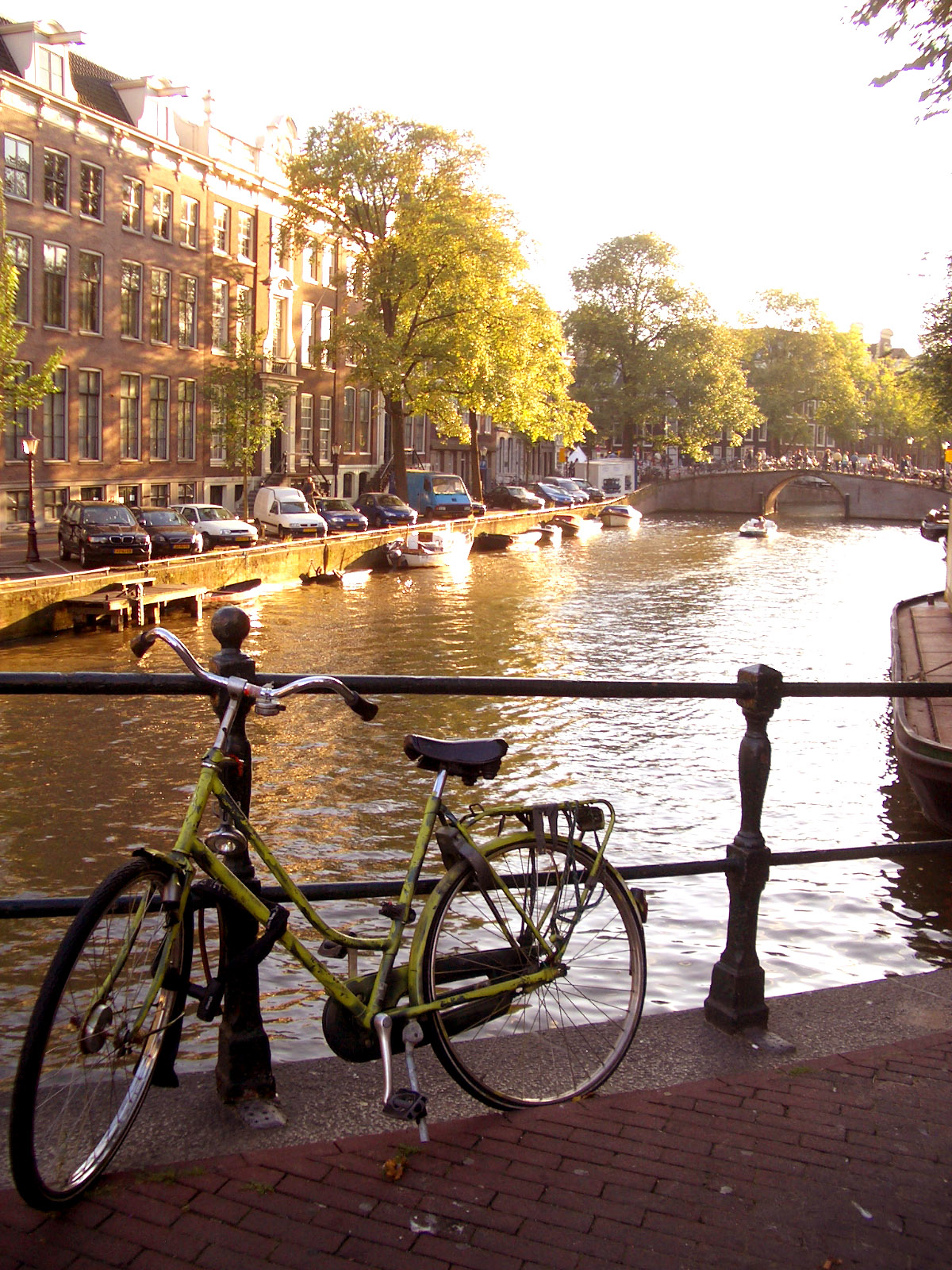 a bicycle on a railing near a canal with several boats