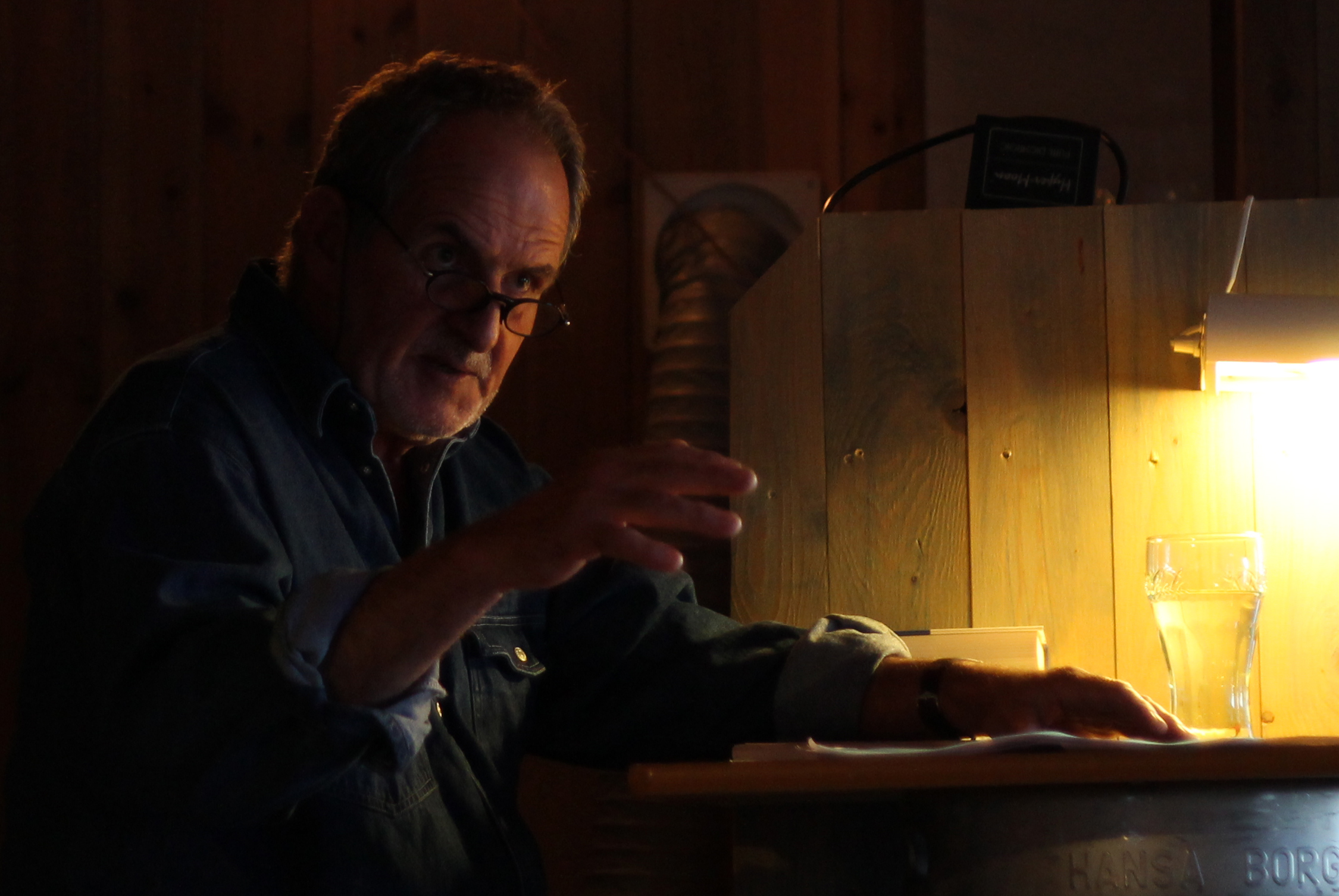 a man sitting at a bar and using a light on top