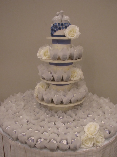a three tier cake with flowers on the side of it