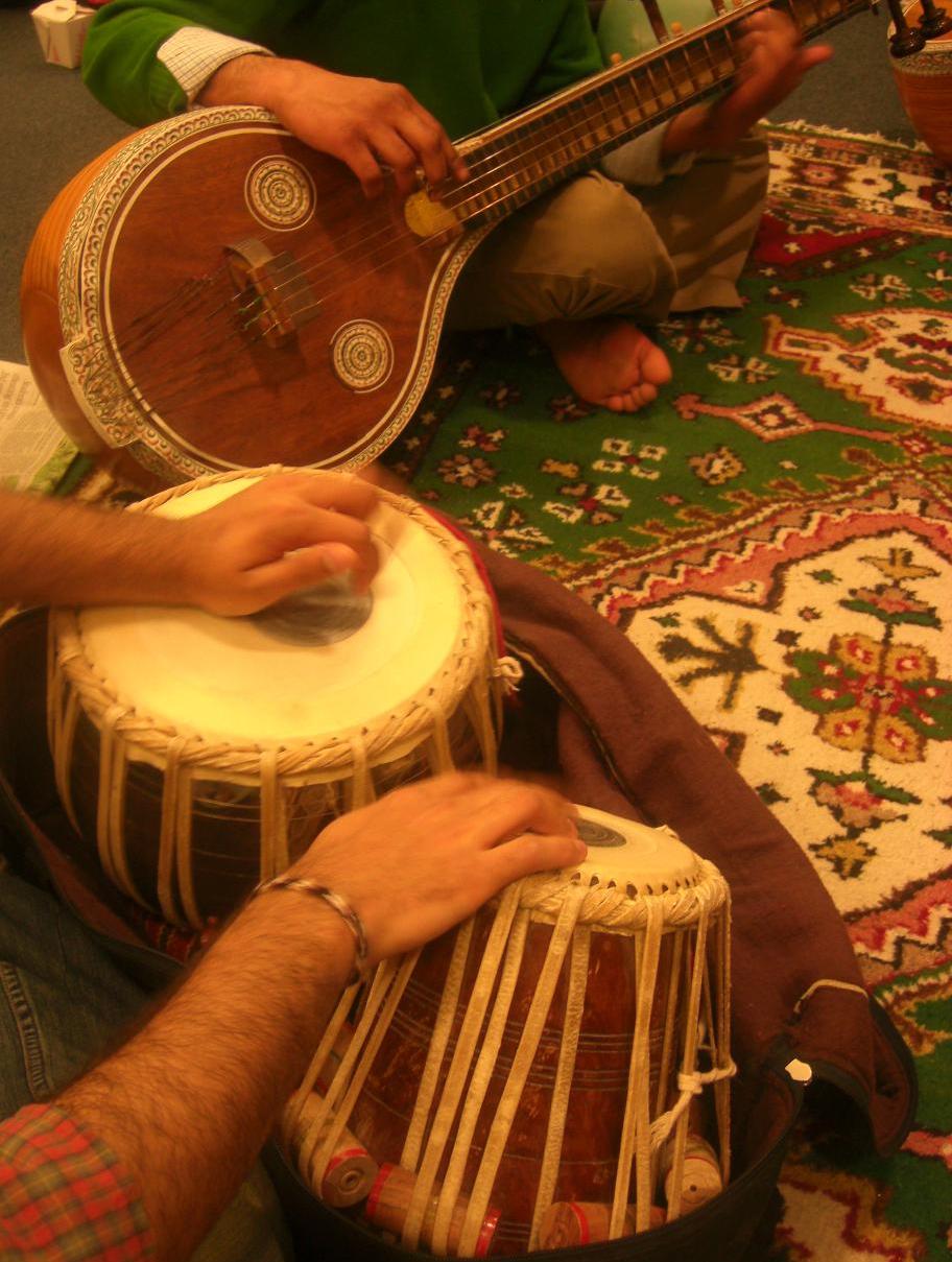 a man playing the djule on a rug