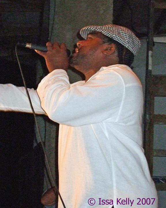 a man in a white top holding a microphone up