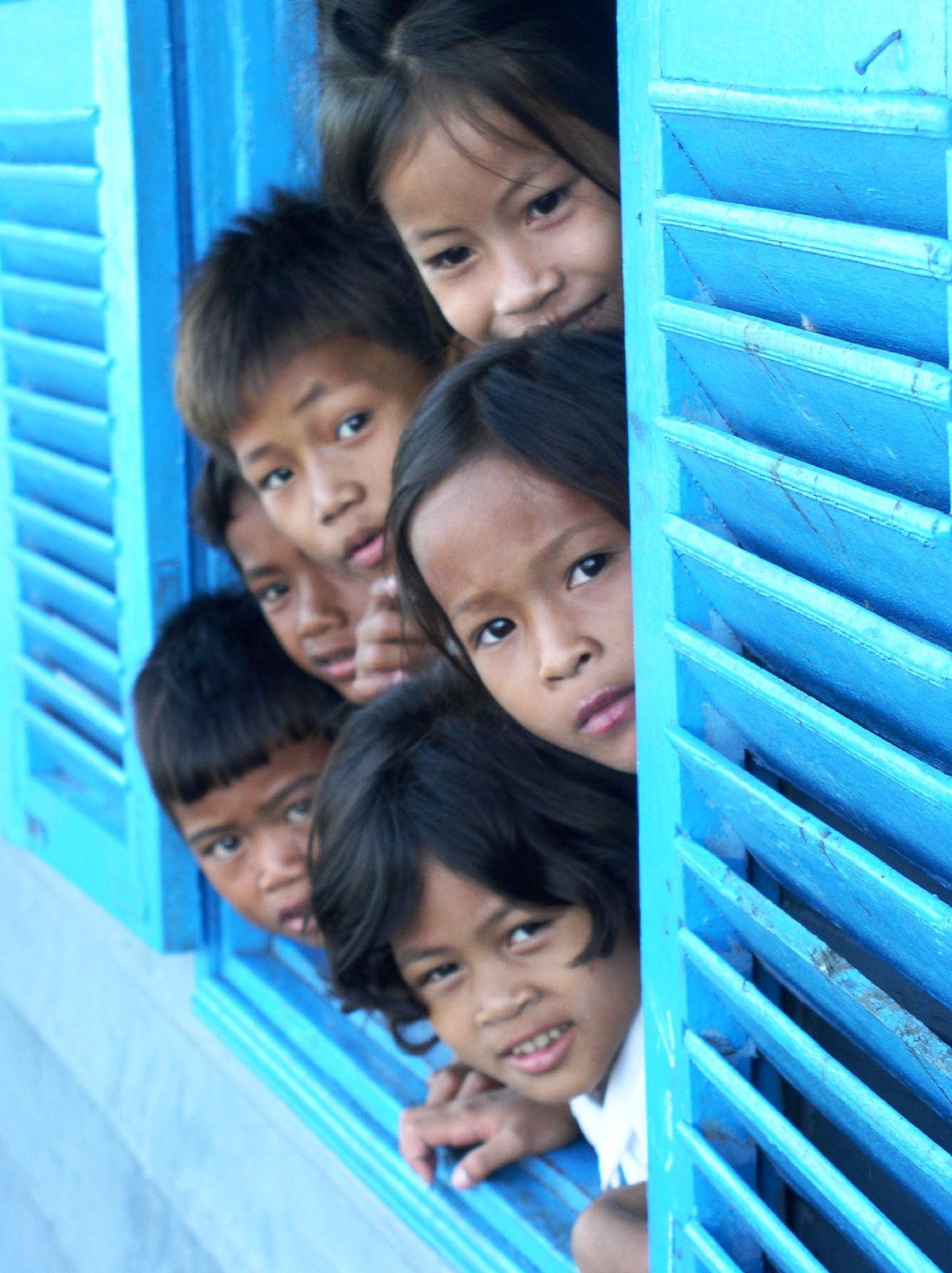 a group of children looking out from a window