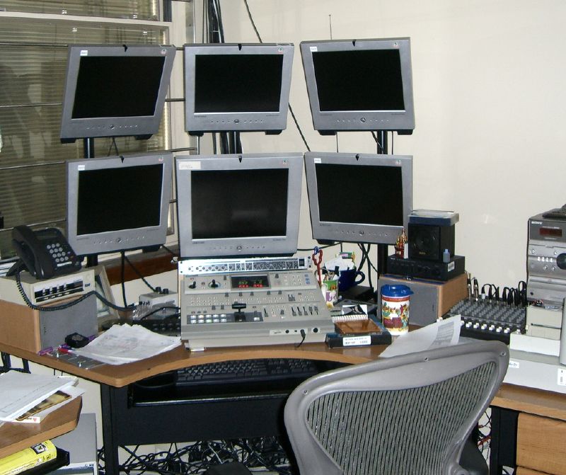 several computer screens sitting next to each other on a wooden desk
