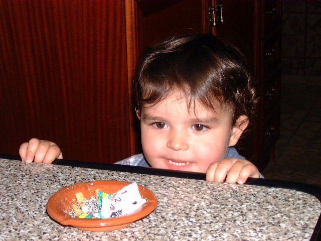 a little boy is sitting at a table eating cake