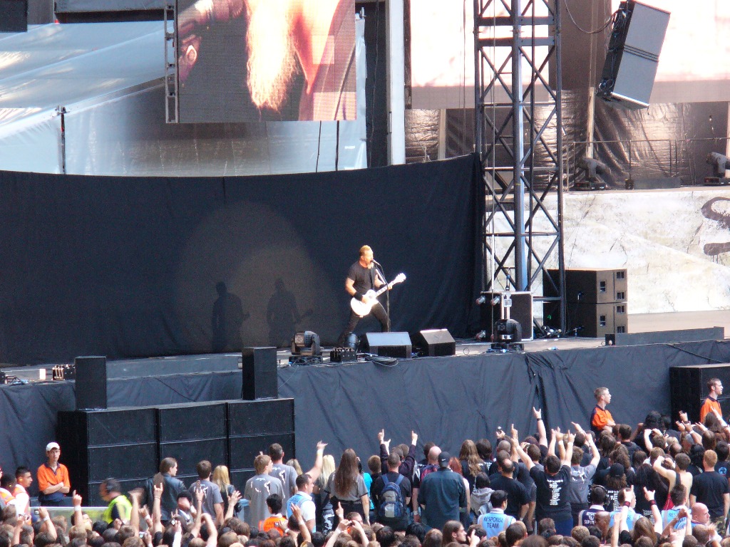 a person playing guitar in front of a large crowd