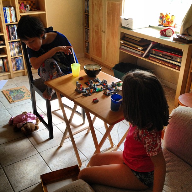 two young children playing with toys on a table