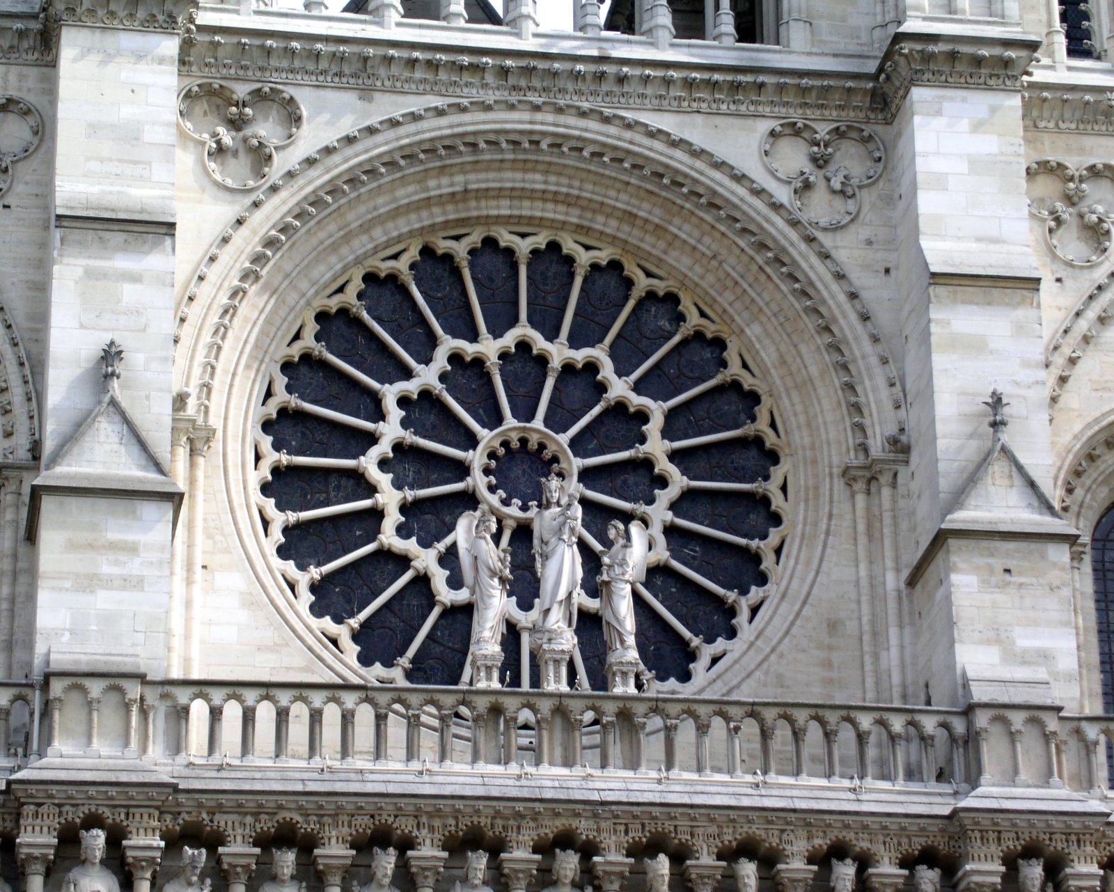 a large cathedral window has statues by it