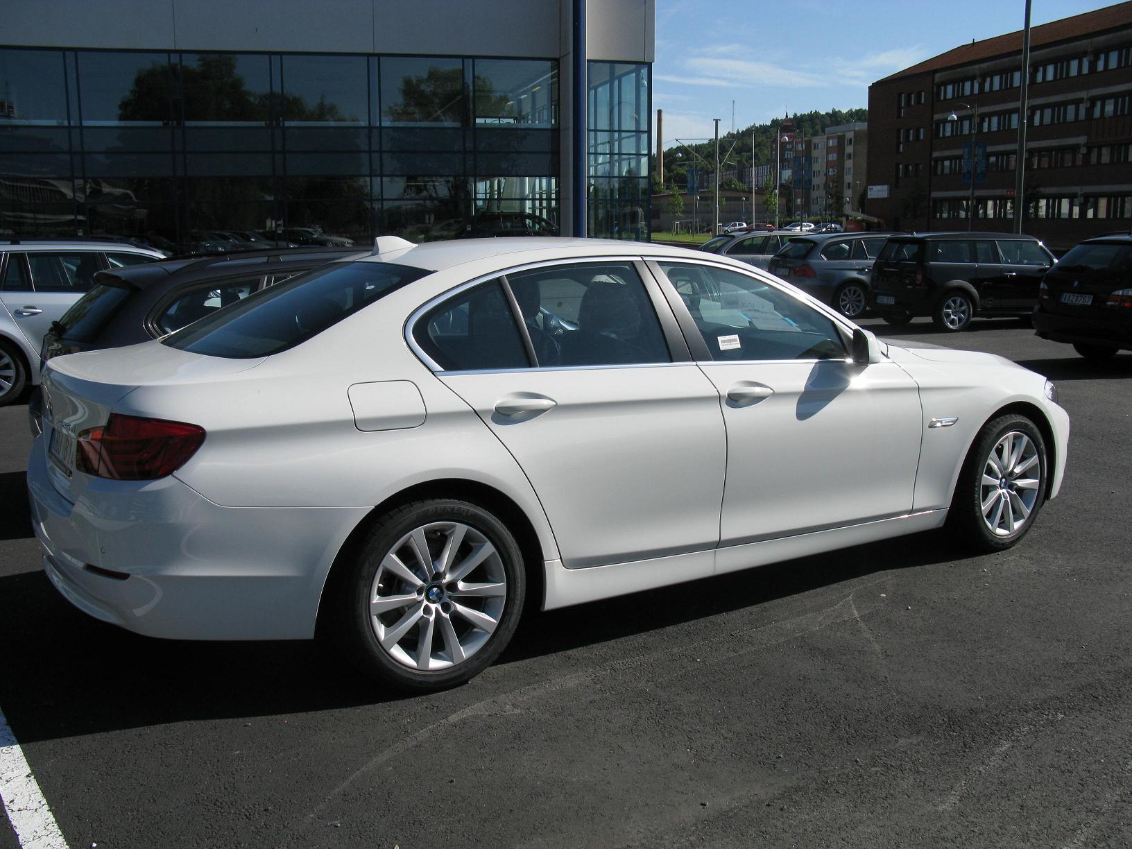 a white bmw parked in front of a building