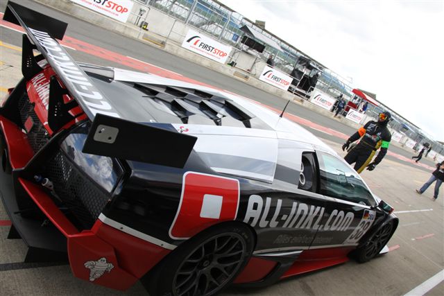 a red car sitting on the side of a race track