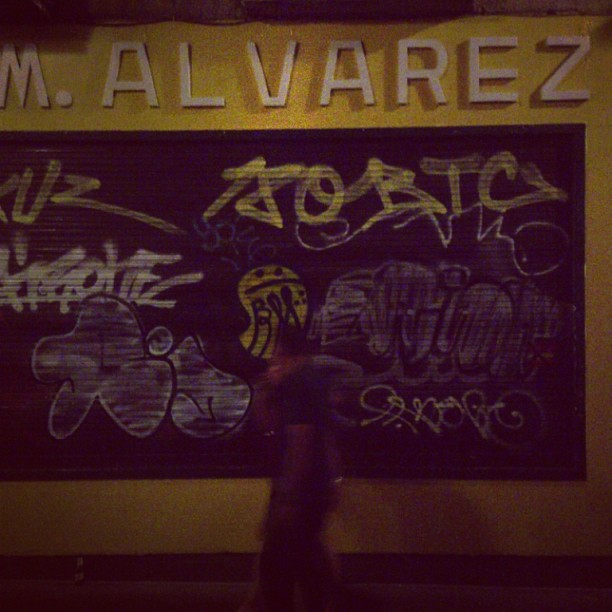 a sign with graffiti written on it is displayed on the wall