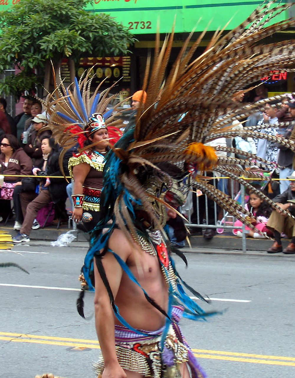 a man in some kind of headdress walking down a street