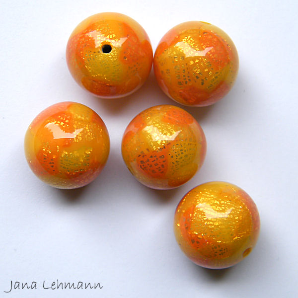 four orange beads are on a white background