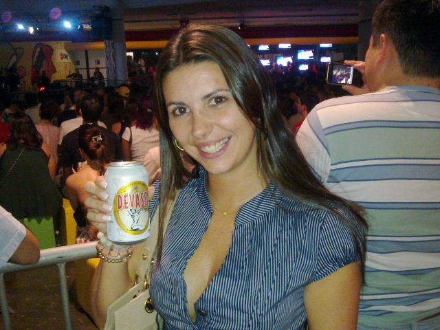 a woman standing at a bar holding onto a beer
