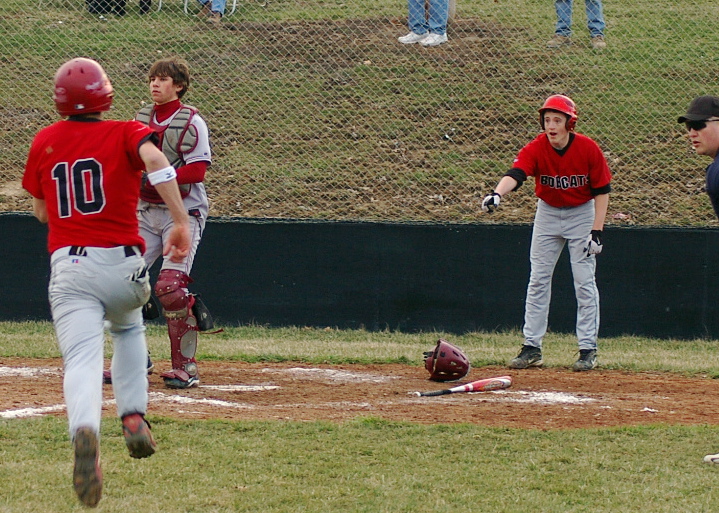 a group of baseball players running to base with one another on the field