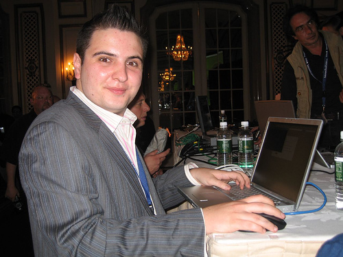 a man sitting at a table using a laptop