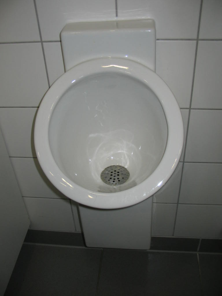 white porcelain sink mounted in the wall of tiled bathroom