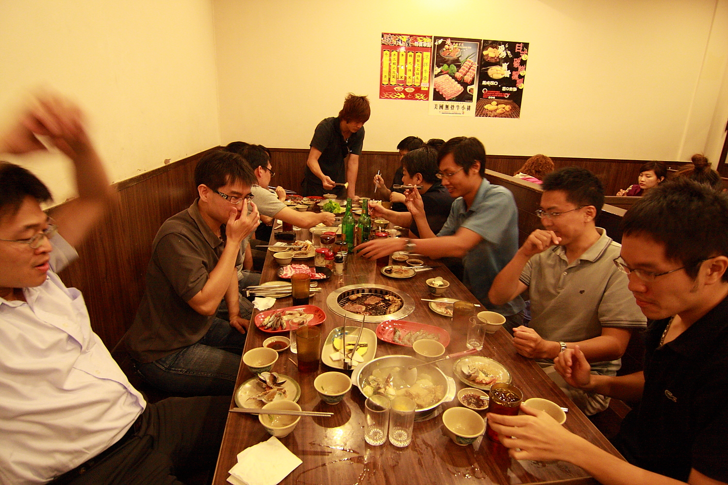 many people are sitting around a long table full of food