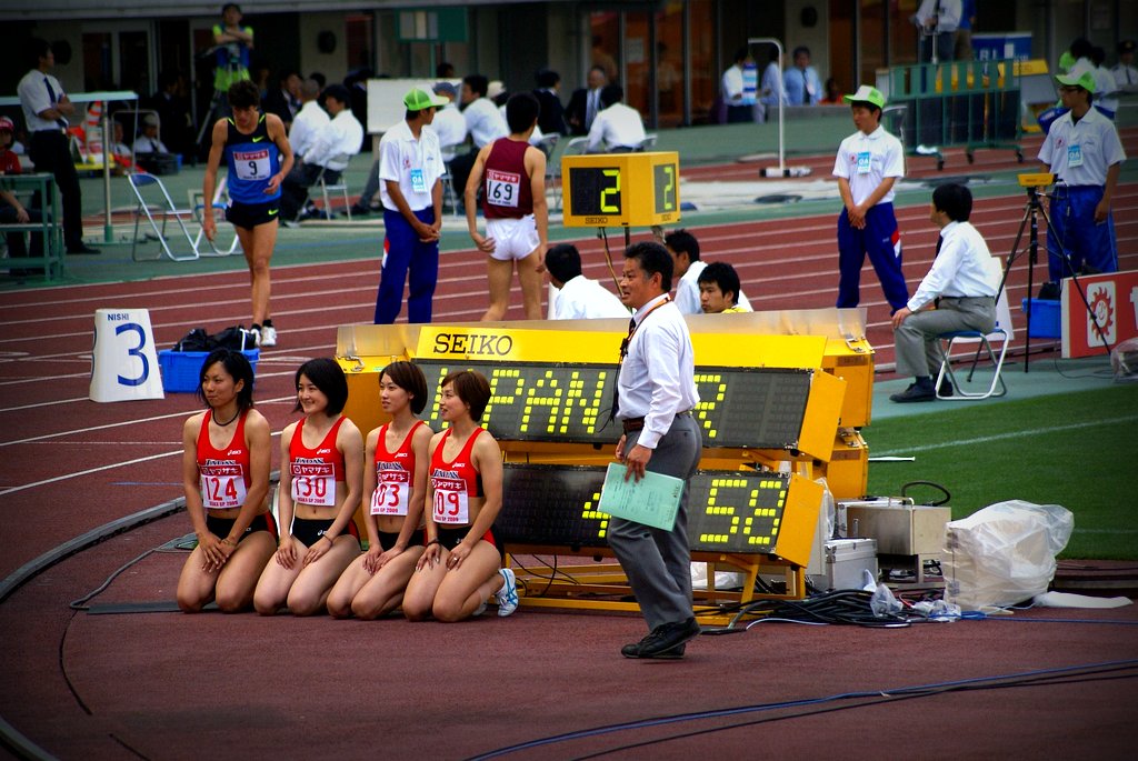 a group of four women sit on a bench