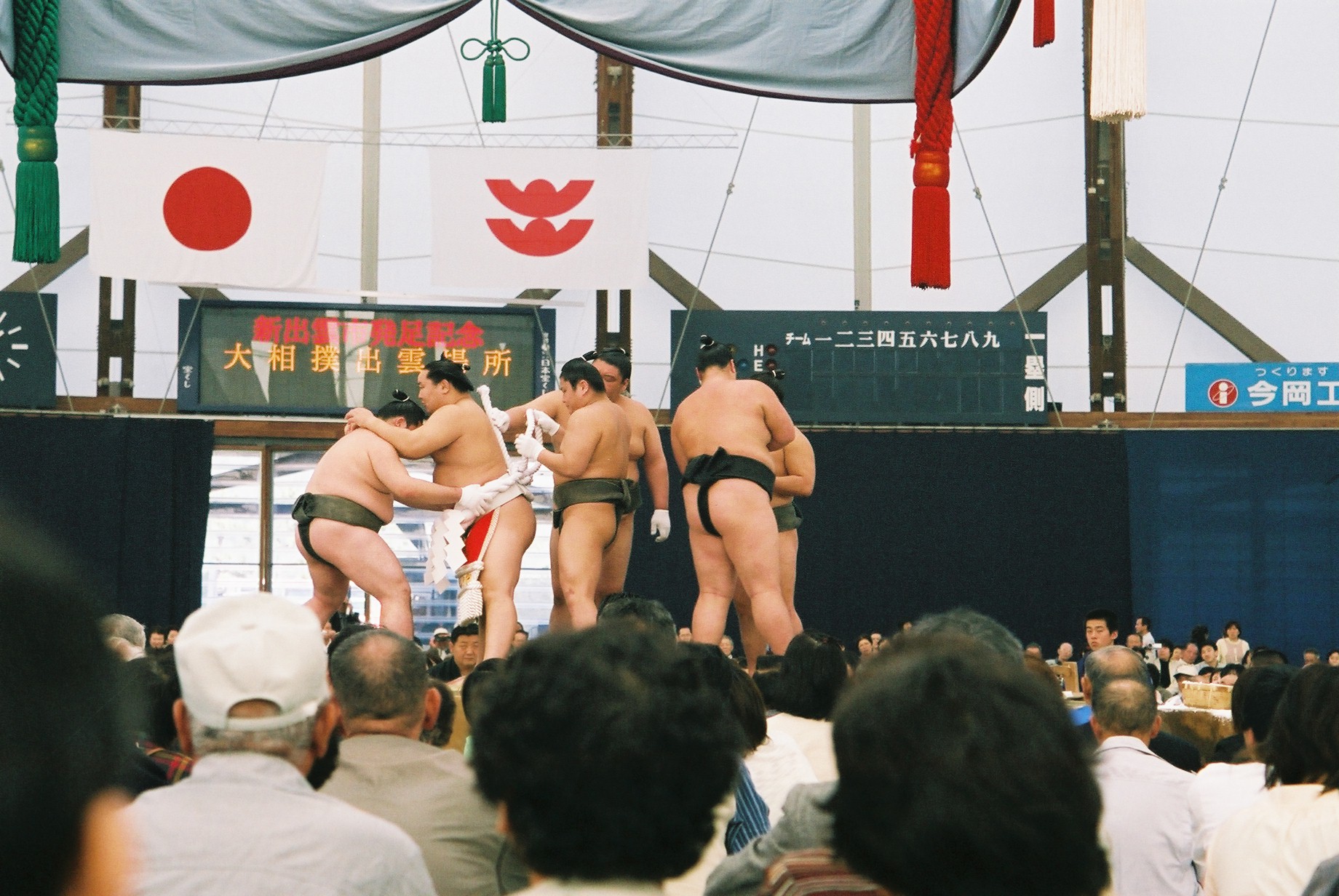 three  men are huddled in front of an audience