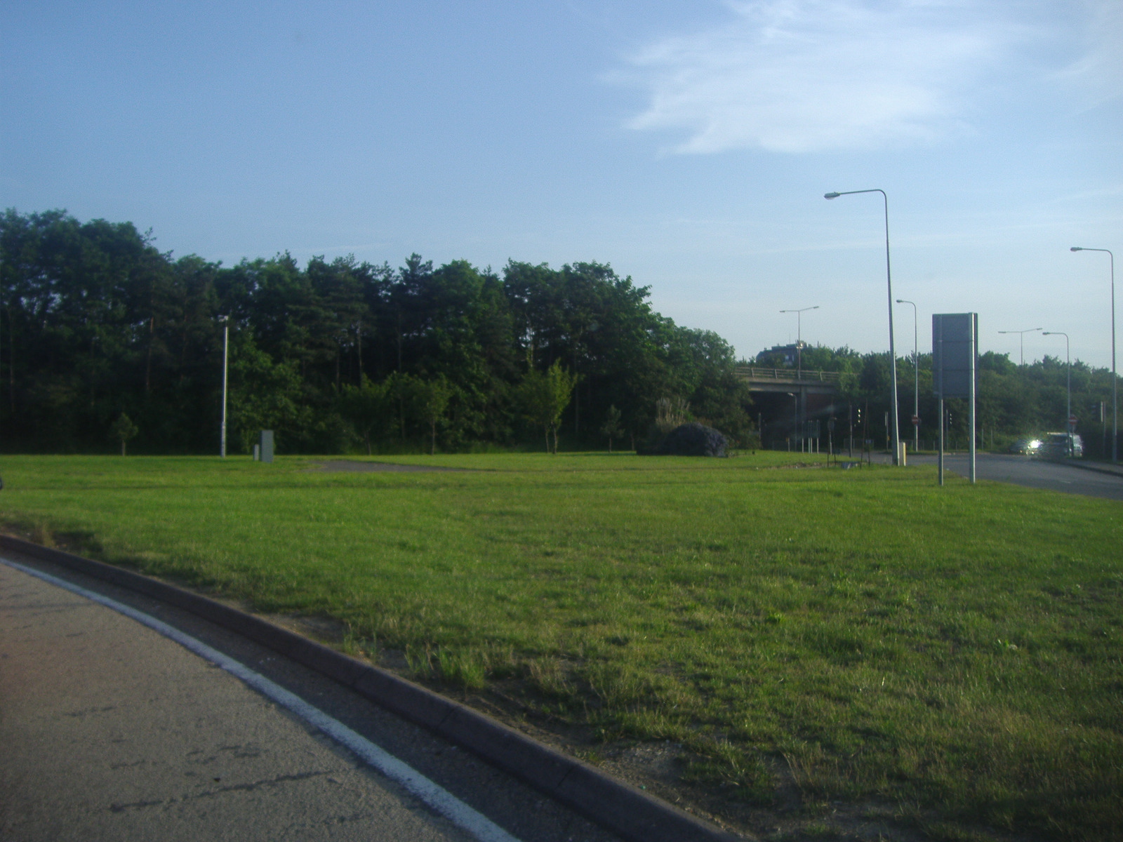 an empty grassy area of an open road