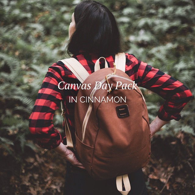there is a woman carrying her backpack in the woods