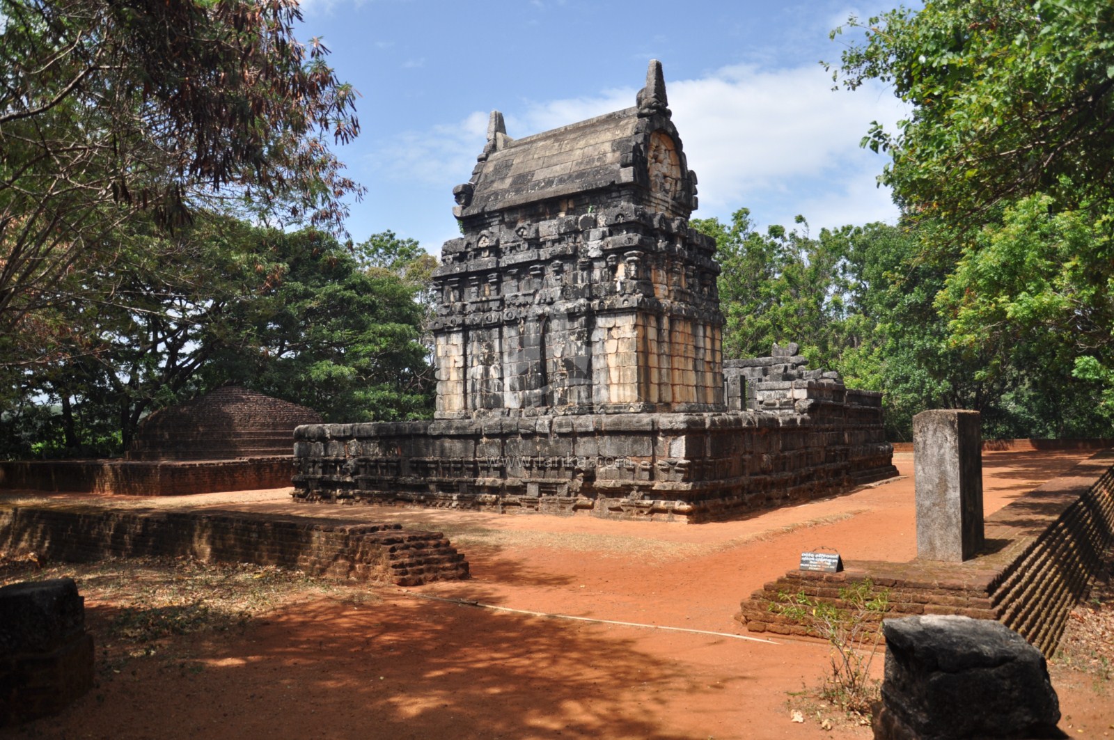 an ancient temple surrounded by trees in a forested area