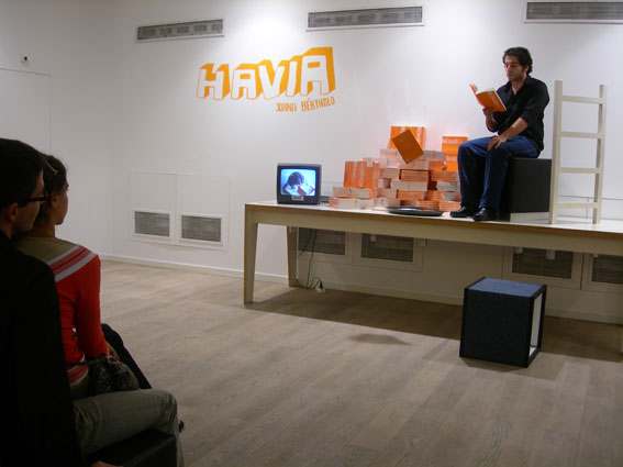 an art installation depicting two men sitting in an orange box