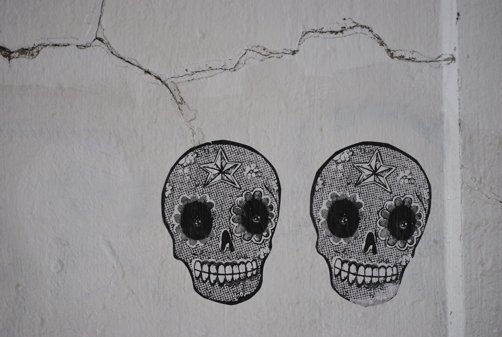 skulls painted on a wall with one facing the camera
