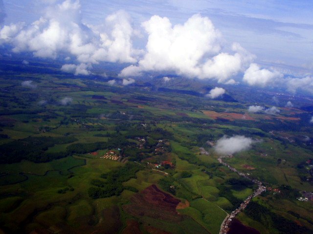 aerial view of farm land with white fluffy clouds