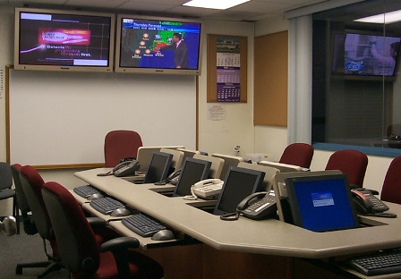 an empty office with two large monitors and several computer screens
