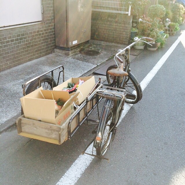 a bike with the wheels extended and a cart full of goods