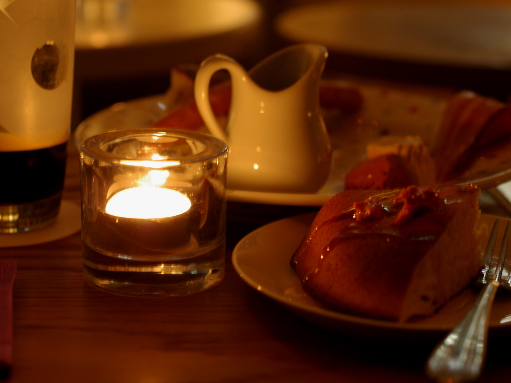 a candle lit by some slices of cake on plates