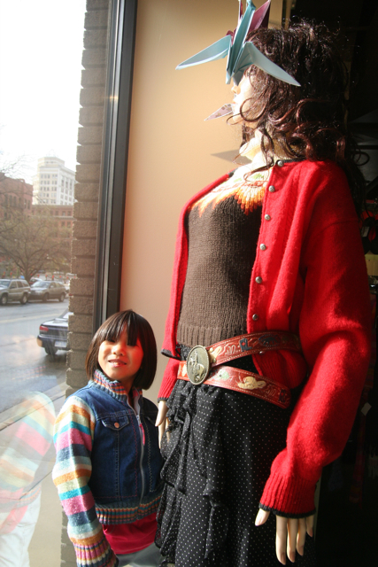 two dolls posed next to each other wearing different kinds of clothing
