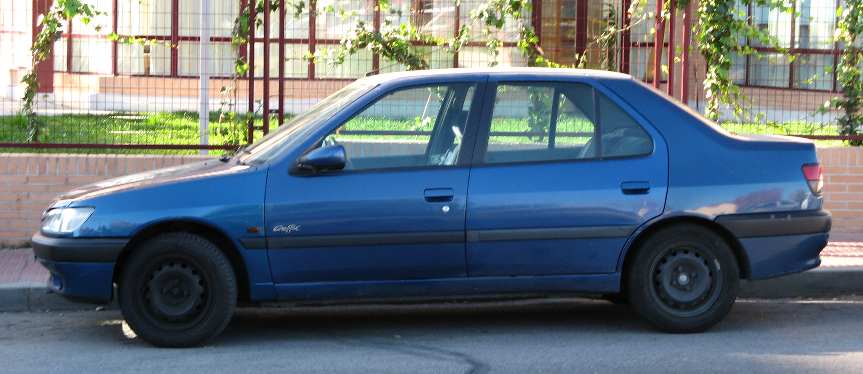 a blue car parked outside with its windows open