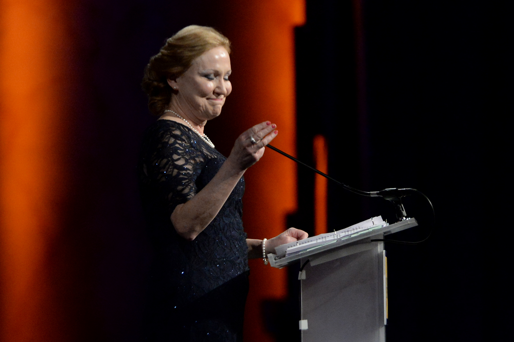 a woman standing at a podium with a microphone in front of her