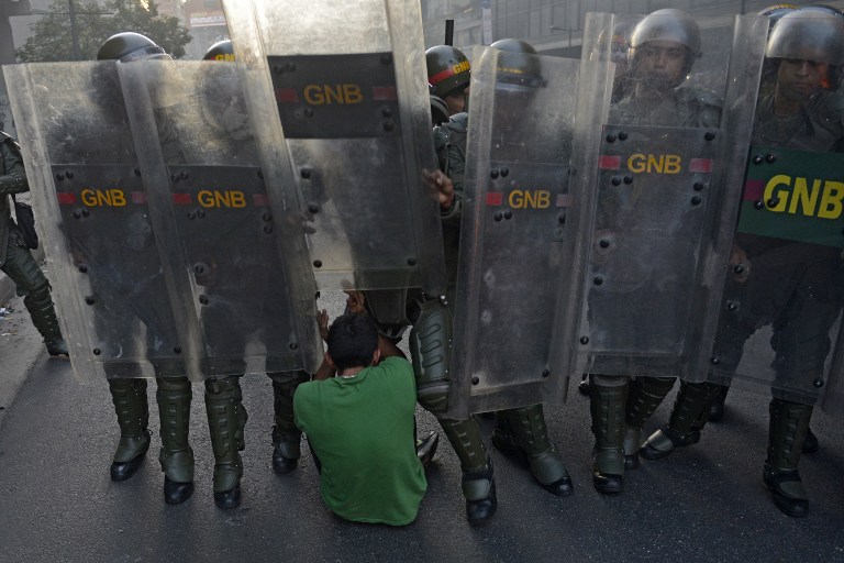 soldiers holding up one another's legs in a line, behind the other soldiers are looking at each other