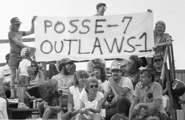 a group of people sitting in a bleachers holding up a banner