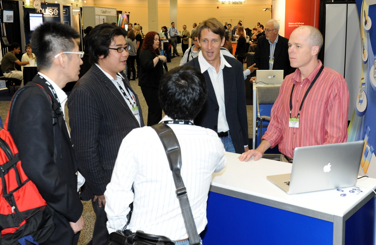 men in business suits are gathered around a computer