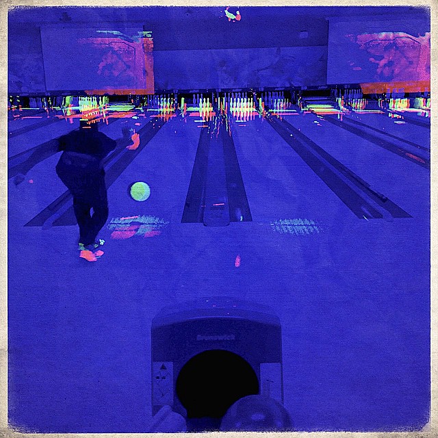 a person on a bowling field that is illuminated by colorful lights