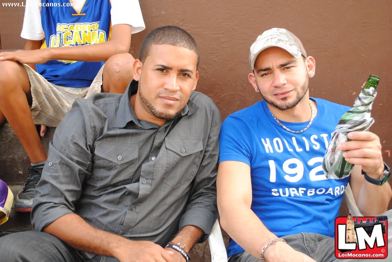 two men sit next to each other with bottles in their hand