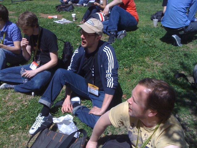 several people sitting on the ground next to a man