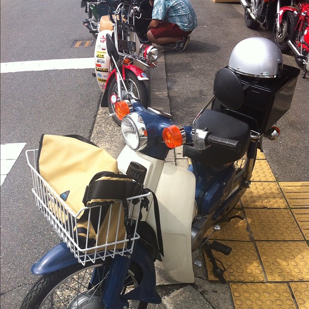 some motorcycles are parked with baskets on the front