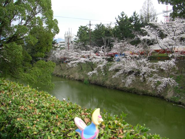 a sculpture of a duck near the water and trees