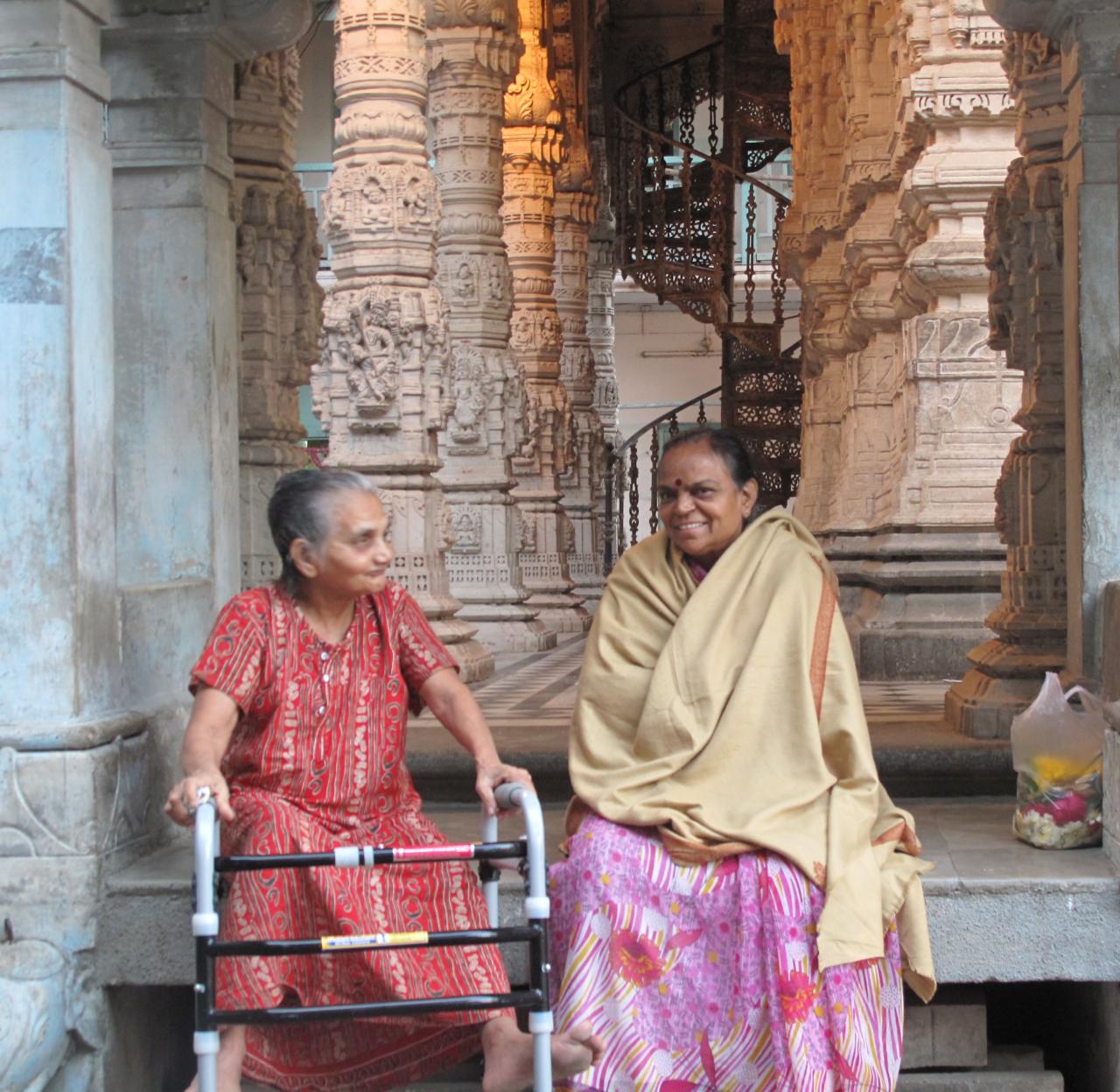 two indian women in colorful clothing at a temple