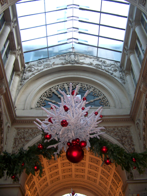 christmas decorations are hung from a ceiling at a building
